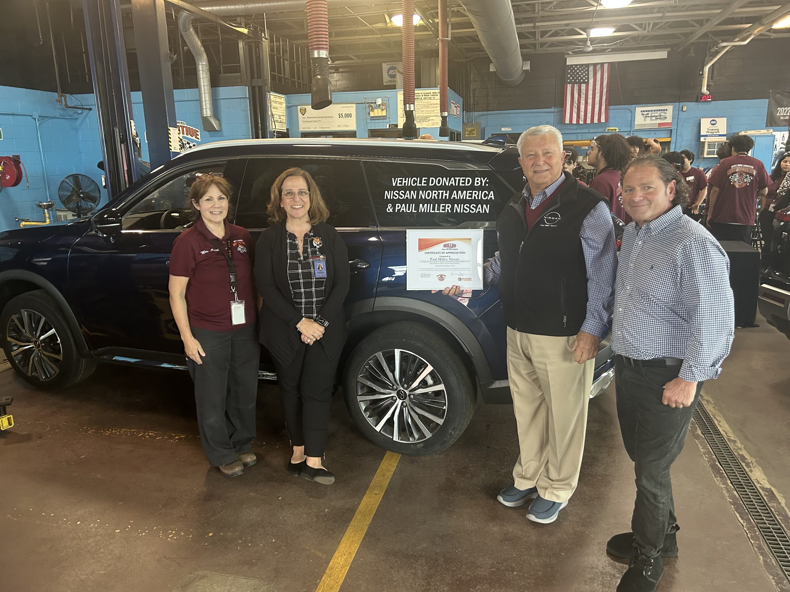 Local Nissan dealership representatives standing in front of donated car to Bullard-Havens auto program.